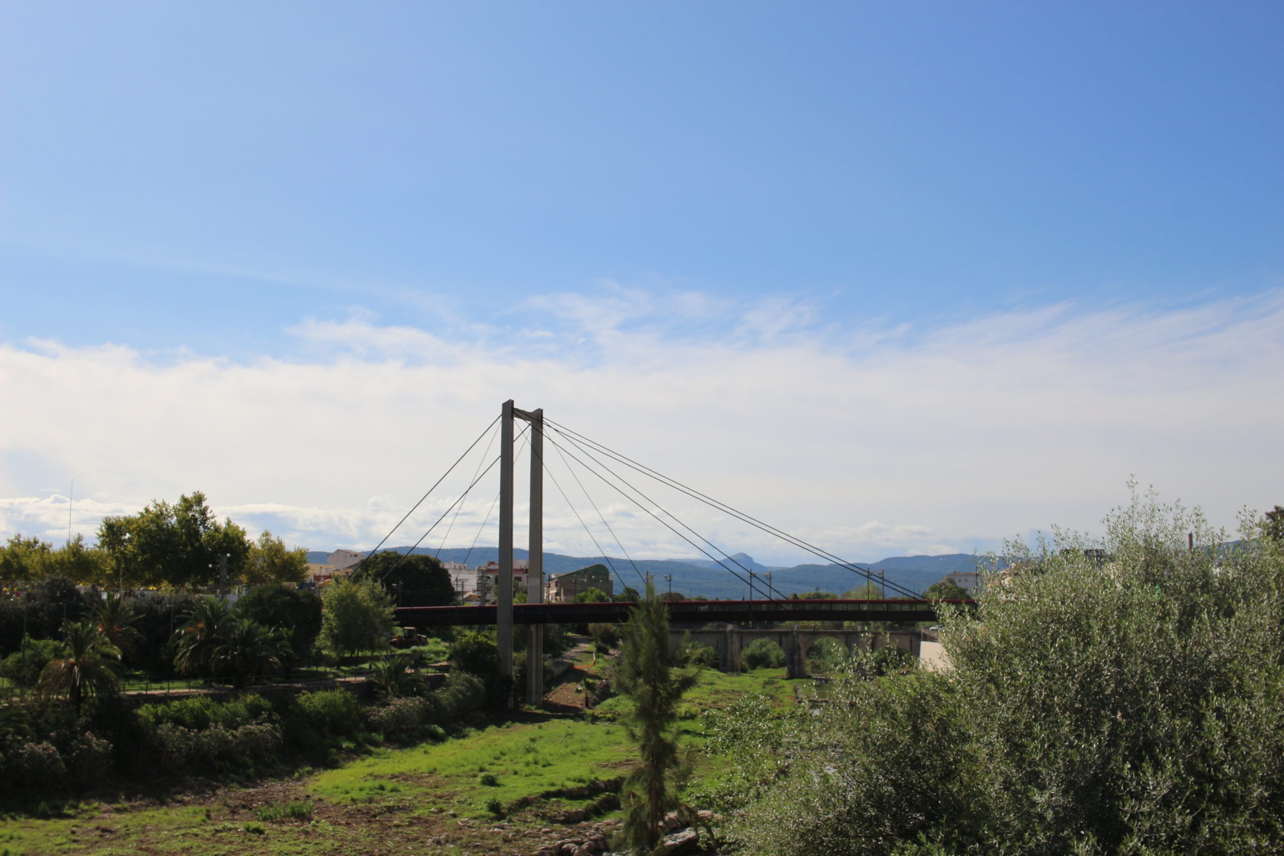 bridge in Gandia in the distance surrounded by greenery