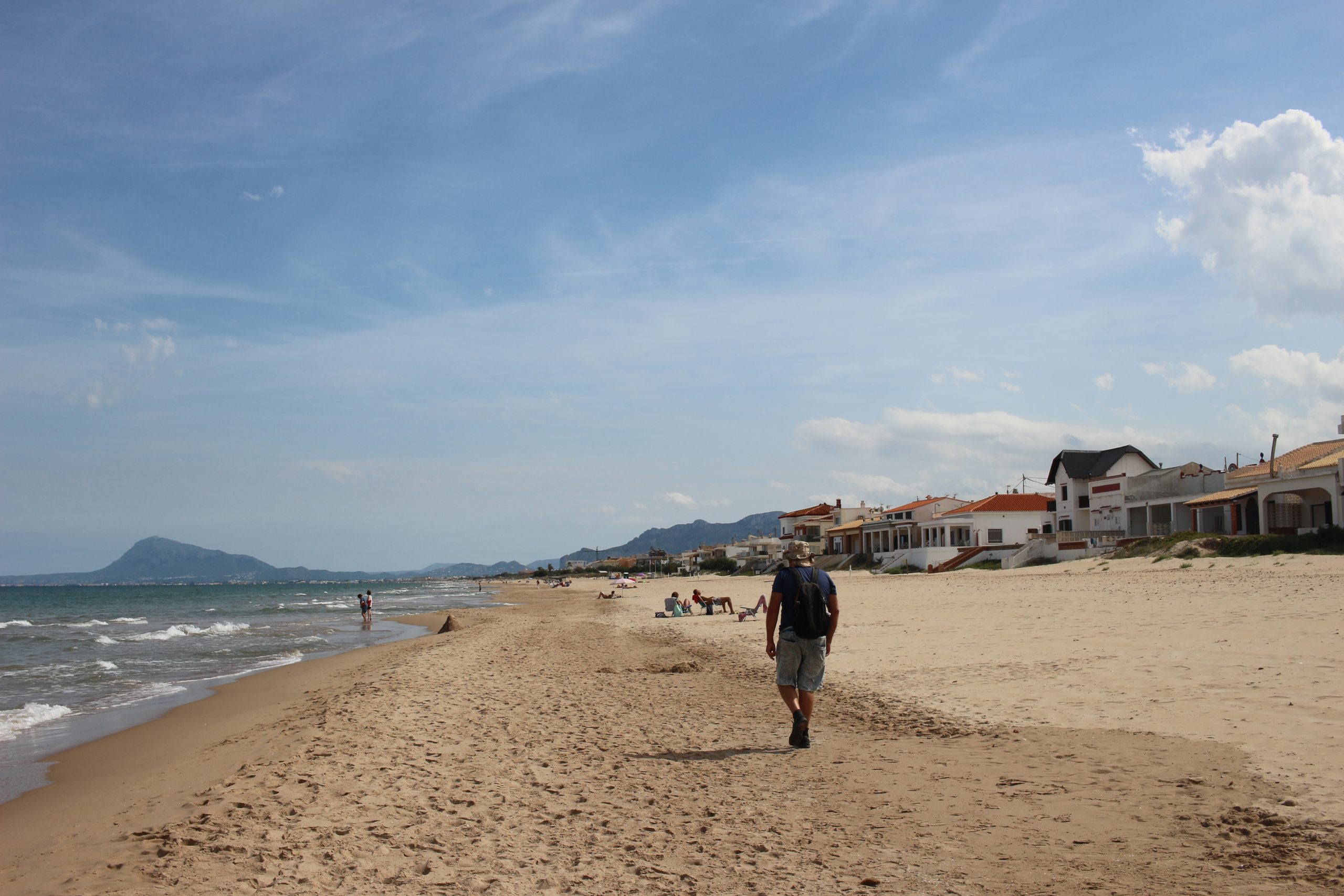 man walking on wide beach